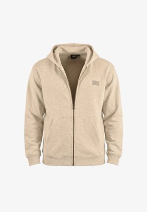 Sweat à capuche zippé beige avec poches à l'avant et petit patch logo rectangulaire sur la poitrine.