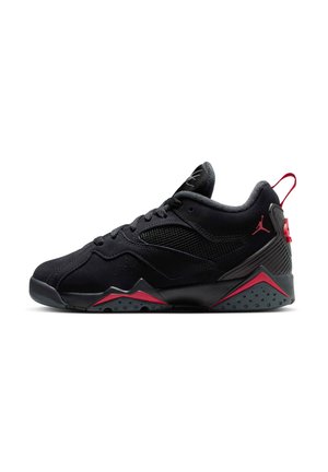 Chaussure de sport noire avec dessus en synthétique, sections en maille, accents rouges sur le talon et la semelle, et une semelle extérieure en caoutchouc avec un motif de crantage.