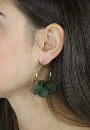 Grüne Blumenohrringe mit einem goldfarbenen Reifen. Sie verfügen über ein kunstvolles Blattmuster auf dem Blütendetail, das eine strukturierte Oberfläche zeigt.