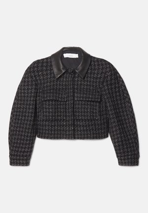 Giacca cropped in tweed bianco e nero con colletto in pelle nera liscia, chiusura frontale con zip e due tasche a toppa. Tessuto texturizzato.