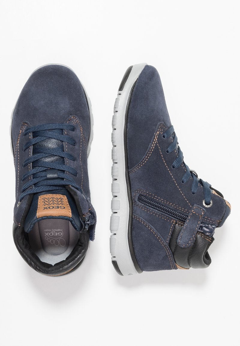 Granatowe zamszowe buty wysokie w stylu sneakersów, z szarymi gumowymi podeszwami, sznurowanym wzorem, bocznym zamkiem oraz brązowymi skórzanymi akcentami na języku i pięcie.