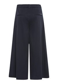 Navy culottes with a wide leg design, elastic waistband, two back pockets, and smooth texture. Minimalistic detailing on the back.