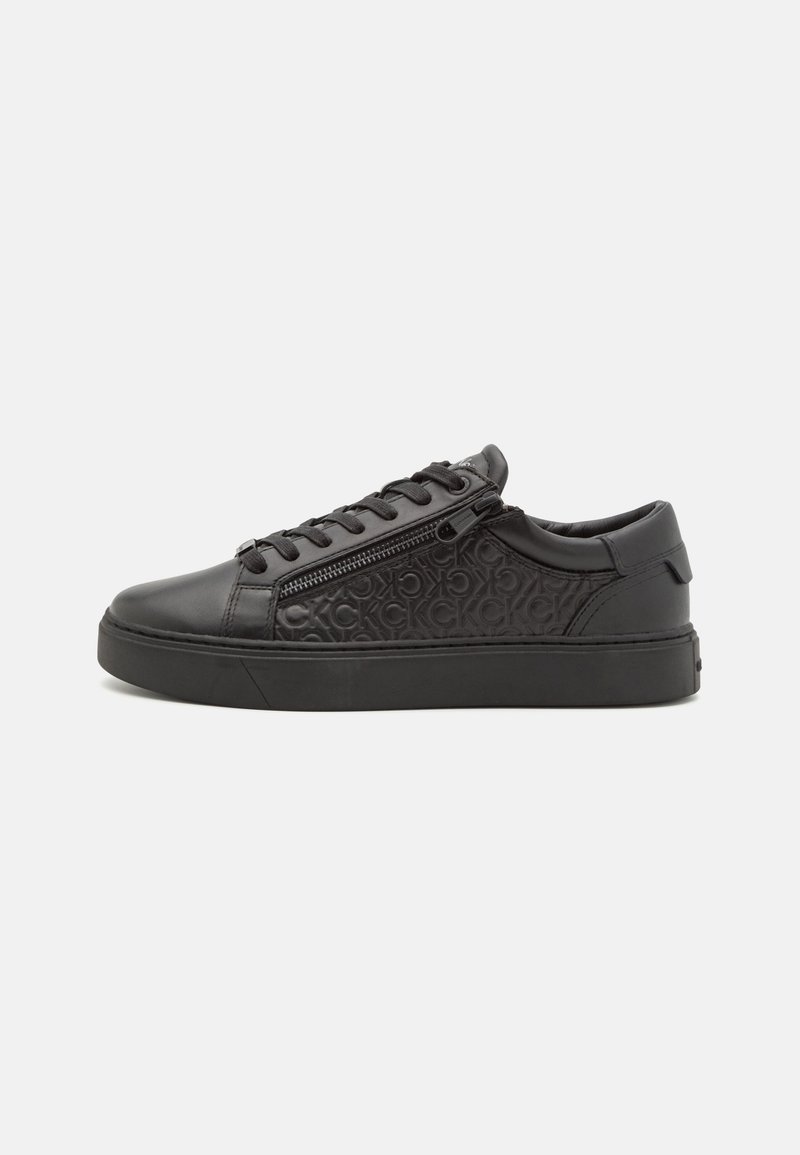 Zapatilla de cuero negra con panel lateral texturizado, puntera redondeada, cordones tonalizados y suela de goma. Cuenta con un zipper lateral.
