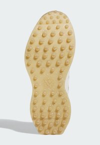 Rubber shoe sole with a textured yellow surface featuring raised circular and hexagonal patterns. Smooth edge with a logo detail.