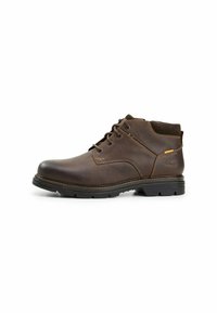 Bruine leren enkelboots met een ronde neus, vetersluiting aan de voorkant, bruine rubberen zool en contrasterende stiksels. Bevat een klein logo-accent.
