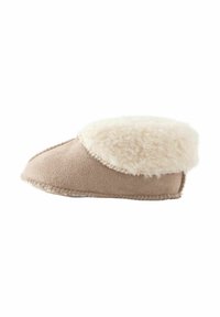 Chausson en beige doux avec un revers en fausse fourrure crème, extérieur en daim moelleux, bout arrondi et détails piqués le long de la semelle.