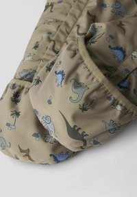 Tissu léger marron avec un motif de dinosaure coloré dans des nuances de bleu et de vert, avec des poches et une texture matelassée.