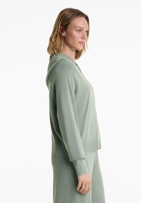 Ljusgrön ribbad hoodie med en avslappnad passform, har en huva och långa ärmar, texturerad tyg och rak nederkant.