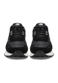 Melni sporta apavi ar gludu un teksturētu materiālu sajaukumu. Izceļas ar baltu logotipu, melnām šņorēm un polsterētu apkakli. Minimālistisks dizains.