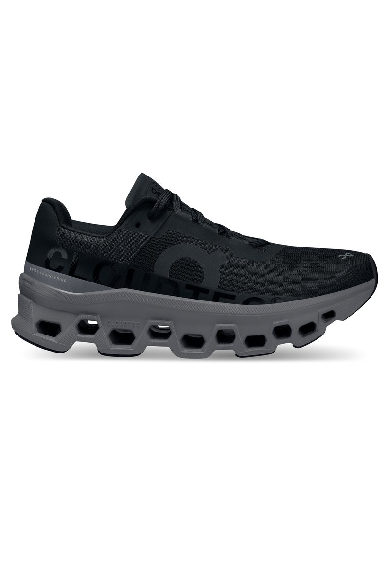 Svart atletisk sneaker med en texturerad ovandel, hexagonal dämpande sula och subtil logotypdetalj på sidan för förbättrad prestanda.