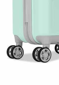 Harde koffer in mintgroen met een gestructureerd oppervlak, grijze accenten, een dubbele rits en vier multidirectionele zwarte wielen.