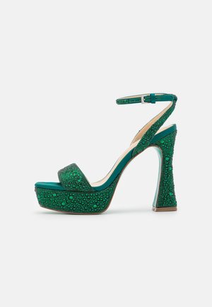 Sandale à talons hauts verte avec une surface texturée, des accents sphériques, une plateforme, une bride de cheville et un talon en bloc transparent.