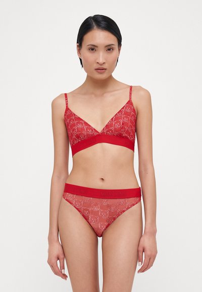 Bralette en dentelle rouge et culotte assortie avec une ceinture logo. Les deux pièces ont un motif floral et des bretelles fines ajustables.