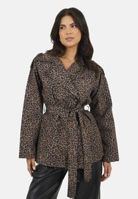 Kurtka w panterkę w odcieniach brązu i czerni, z paskiem w talii, podwójnymi guzikami, szerokimi rękawami i z wyciętym kołnierzem.