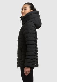 Giacca a vento nera con cappuccio, caratterizzata da sezioni trapuntate verticali, tasche laterali con zip e patch con logo sulla manica.