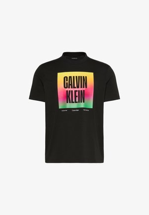 Must lühikeste varrukatega T-särk, millel on värviline gradientruut ja suur "CALVIN KLEIN" tekst ees, allosas väikeste brändi detailidega.