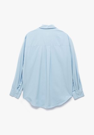 Lichtblauwe langwerpige blouse met een klassieke kraag, rugplooidetail en knoopmanchetten, gemaakt van gladde stof met een zachte textuur.