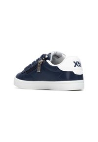 Zapatilla de cuero sintético azul marino con detalles en blanco, con cremallera lateral y suela de goma blanca. Logo visible en el talón.