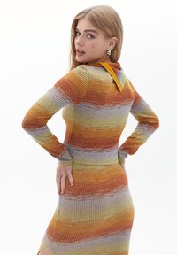 Knit dress with long sleeves, featuring orange, yellow, and blue horizontal stripes. Collared neckline and textured fabric with ribbing.