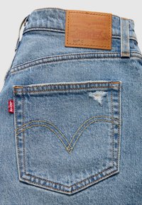 Πίσω τσέπη από τζιν Levi’s 501 ανοιχτού μπλε χρώματος με ραμμένο σχέδιο αψίδας, μικρό σχίσιμο και ταμπά δερμάτινο λογότυπο στη μέση.