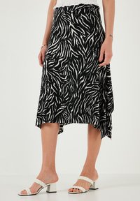 Črno-bela zebra potiskana krila z lahkotnim dizajnom, asimetričnim robom in lahko teksturo, v kombinaciji z belimi sandali na blok peto.