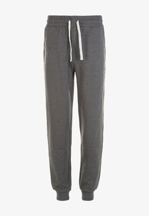 T-shirt orange à manches courtes associé à un pantalon de survêtement gris foncé et des baskets grises. Le tissu semble doux avec une coupe décontractée.