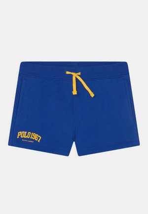 Calções azuis feitos de tecido suave, com cordão amarelo e bolsos. A parte da frente exibe o texto "POLO 1967" em costura amarela.