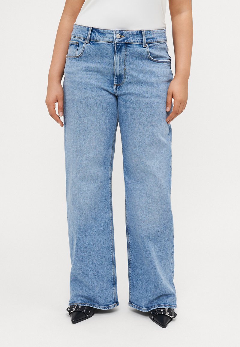 Gaiši zili plataji džinsi, izgatavoti no denim auduma, ar priekšējiem kabatām, pogu aizdari un nodilušu tekstūru pie apakšmalas.