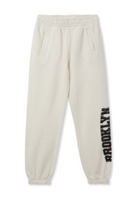 Joggery w kolorze kremowym wykonane z miękkiego materiału. Posiadają elastyczny pasek w talii, dwie boczne kieszenie oraz grafikę "BROOKLYN" na lewej nodze.