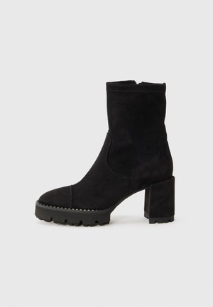 Bottes de cheville noires en daim avec un bout carré, un talon épais et une semelle en caoutchouc texturée avec des accents en zigzag. Fini lisse.
