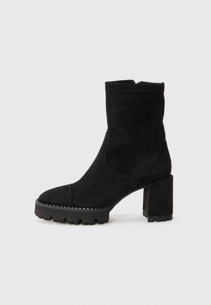 Black ankle boots made of suede with a square toe, chunky heel, and textured rubber sole featuring zigzag accents. Smooth finish.