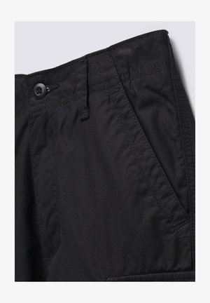 Černé kalhoty z hladké tkaniny, s knoflíkovým zapínáním, bočními kapsami a viditelným švem podél pasu a kapes.