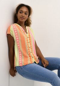 Blusa a maniche corte con placket abbottonato. Presenta vivaci strisce verticali arancioni, rosa e gialle e motivi geometrici. Tessuto leggero.