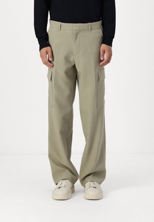 Khaki cargo pants with a loose fit, featuring two side pockets and a smooth texture. Paired with light sneakers on a neutral background.