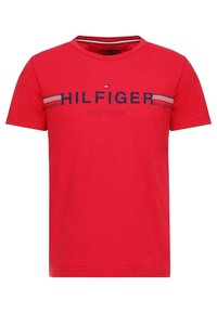 Punainen lyhythihainen crew neck -t-paita, jossa on "HILFIGER NEW YORK" -teksti ja pieni logo keskittyneenä rinnassa vaakasuorien raidallisten yksityiskohtien kanssa.