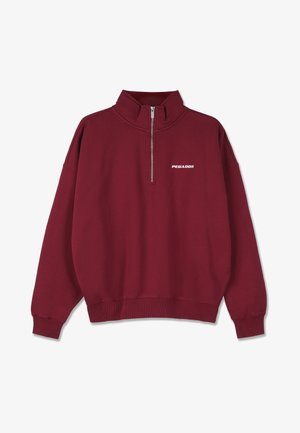 Bordo polar pulover s visokim ovratnikom, polu-čičak sprijeda i rebrastim manžetama. Sadrži bijeli "PEGADOR" logo na prsima.