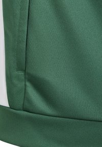 Grüner Stoff mit strukturiertem Finish, der ein kontrastierendes weißes Seitenpanel und einen gerippten Saum aufweist. Einfaches, funktionales Design.