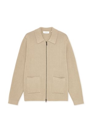 Cárdigan de punto beige con cremallera frontal, cuello plano y dos bolsillos parche. Presenta una tela texturizada y una silueta relajada.