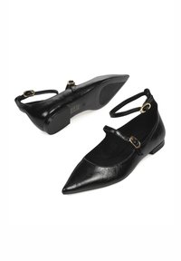 Bailarinas de cuero negro con punta afilada, tira de tobillo y detalle de hebilla dorada. Textura suave con suela plana.