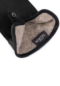 Black leather glove with a tan wool lining. Features a snap closure and a visible label reading "ROECKL MÜNCHEN." Smooth exterior finish.