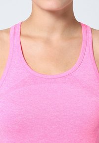 Canottiera atletica aderente rosa realizzata in materiale morbido e traspirante. Presenta un collo a barchetta e una costruzione senza cuciture per il massimo comfort.