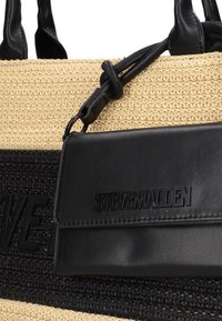Geweven stro tote bag met zwarte leren accenten, een afneembare zwarte leren pouch en een gestructureerd oppervlak met logo-detail.