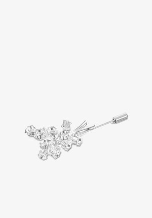 Zestaw srebrnych metalowych czapeczek do koralików w kształcie kwiatów z długim metalowym narzędziem igłowym, ułożony na białym tle.