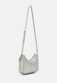 Petit sac à bandoulière en cuir argenté avec bandoulière ajustable et fermeture zippée supérieure, présenté sur un fond blanc uni.