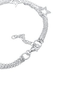 Silverkedjearmband med flera länkade kedjor, stjärnformade detaljer och en kräftklolås för stängning.
