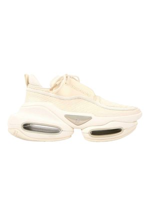 Cream-colored Balmain sneaker with chunky sole, visible air pockets, textured upper, and lace-up design.
