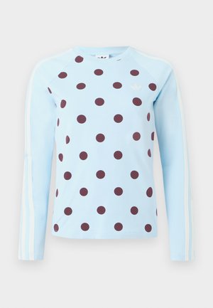 Svetlomodrá košeľa s dlhými rukávmi s tmavohnedými bodkami a bielym logom Adidas a tromi pásmi na rukávoch.