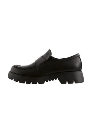 Sort læder slip-on loafer med chunky slidstærk sål og bred rem over skaftet, vist fra siden på hvid baggrund.