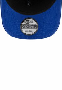 Blaues Cap mit schwarzem Schirm, strukturiertem Stoff und verstellbarem Riemen. Enthält ein rundes, gebrandetes Etikett mit der Aufschrift "9SEVENTY" und "ADJUSTABLE."