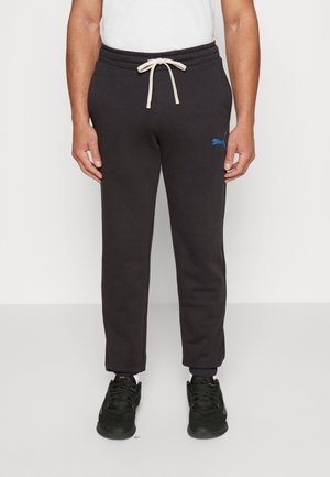 Czarne spodnie dresowe z regulowanym paskiem, z niebieskim logo Puma na lewej udzie i ściągaczami przy kostkach.